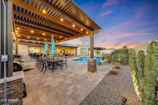 patio terrace at dusk with a fenced in pool