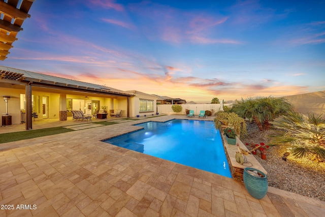 pool at dusk with a patio