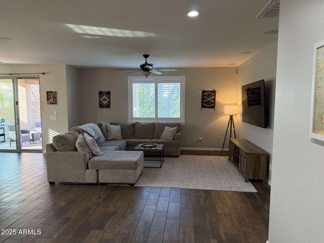 living area featuring a wealth of natural light, visible vents, baseboards, and dark wood-type flooring