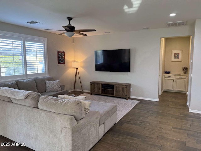 living room with visible vents, dark wood-type flooring, and baseboards