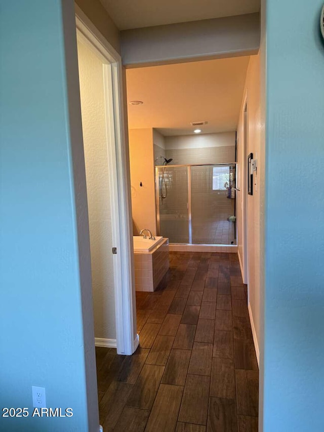 corridor featuring baseboards and wood finish floors