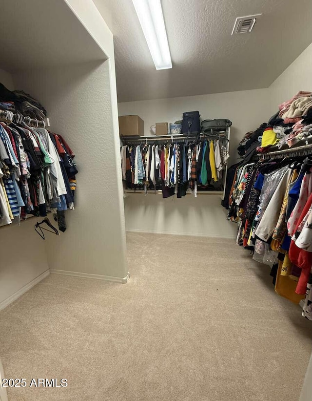 walk in closet with visible vents and carpet floors