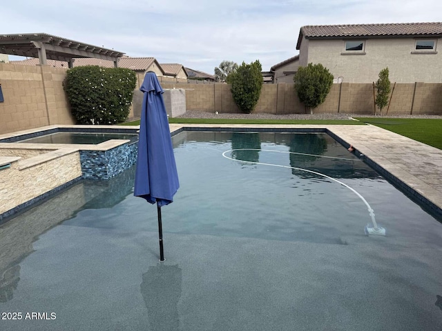 view of swimming pool with an in ground hot tub and a fenced backyard