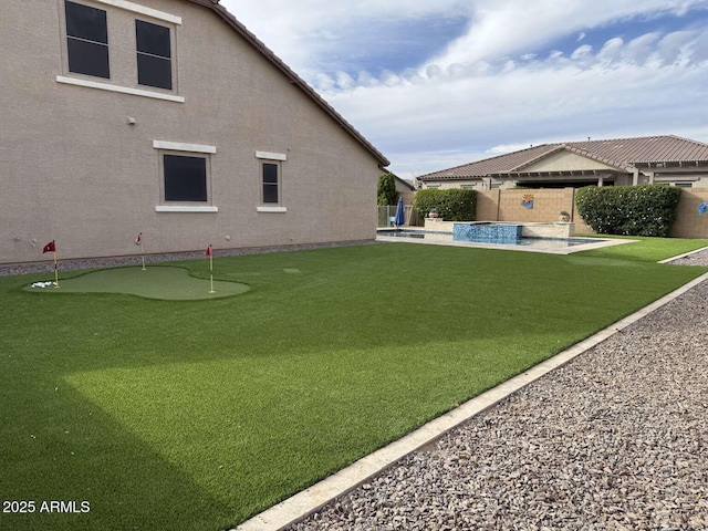 view of yard with a patio area, a fenced backyard, and a pool with connected hot tub