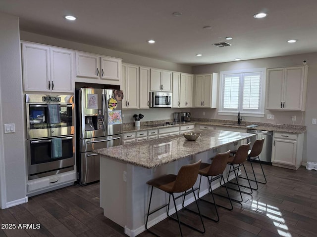 kitchen with white cabinetry, dark wood-type flooring, visible vents, and appliances with stainless steel finishes