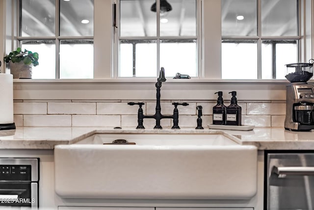 interior details featuring light stone countertops and sink