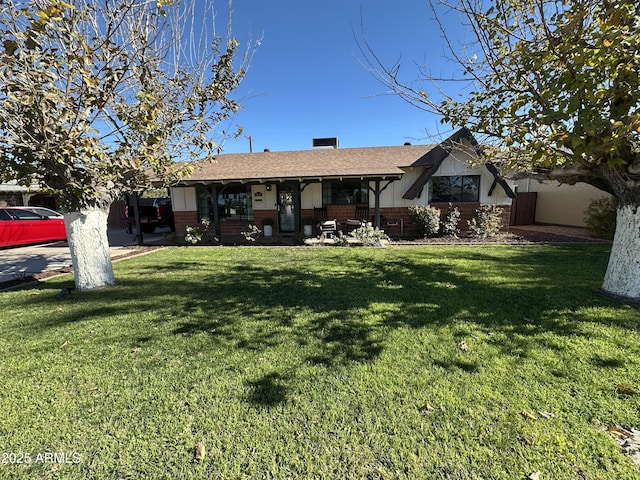 rear view of house featuring a lawn and covered porch