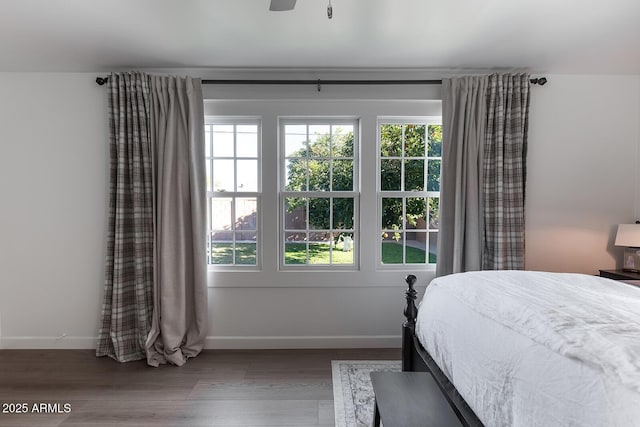 bedroom with multiple windows, hardwood / wood-style floors, and ceiling fan