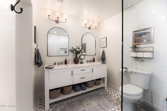 bathroom with vanity, tile patterned floors, tile walls, and toilet