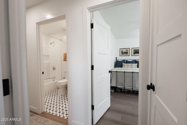 bathroom featuring shower / bath combination, wood-type flooring, and toilet