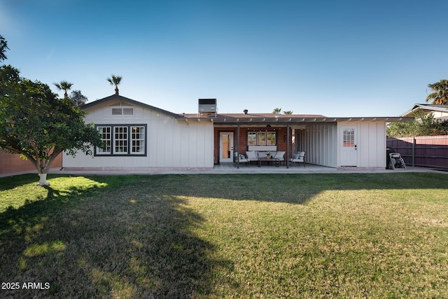 rear view of property with a patio area, central air condition unit, and a lawn