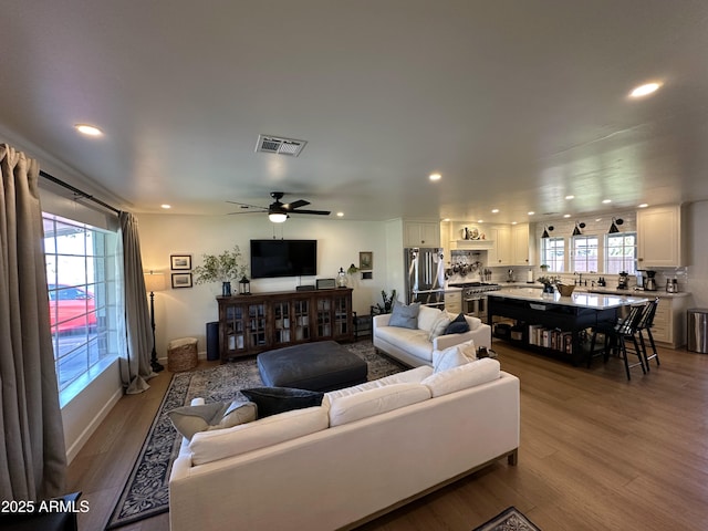 living room with ceiling fan and light hardwood / wood-style flooring