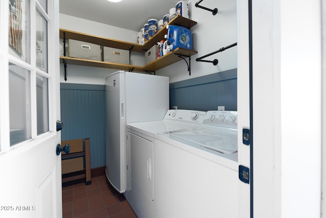 washroom featuring dark tile patterned flooring and washing machine and dryer