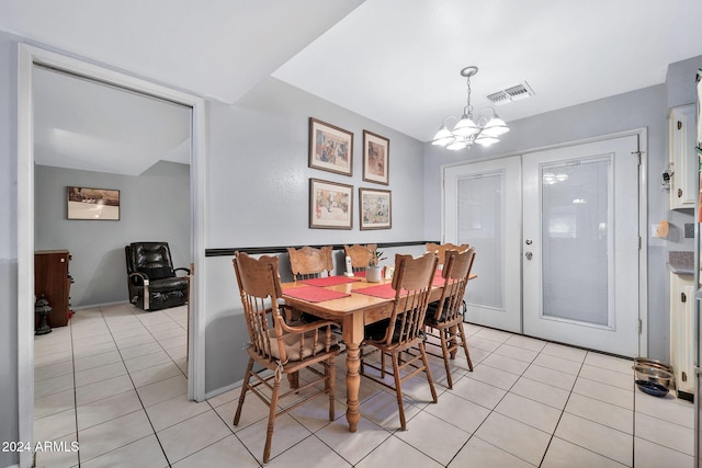 tiled dining space with french doors and an inviting chandelier