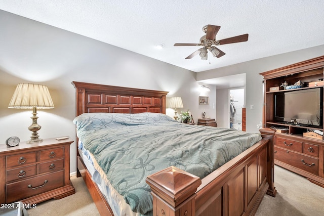 bedroom featuring a textured ceiling, ceiling fan, and light carpet