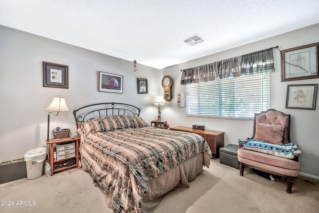 bedroom featuring light colored carpet and a textured ceiling