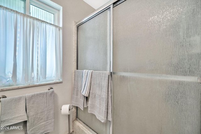 bathroom featuring a shower with shower door