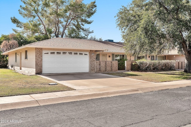 ranch-style home featuring a front lawn and a garage