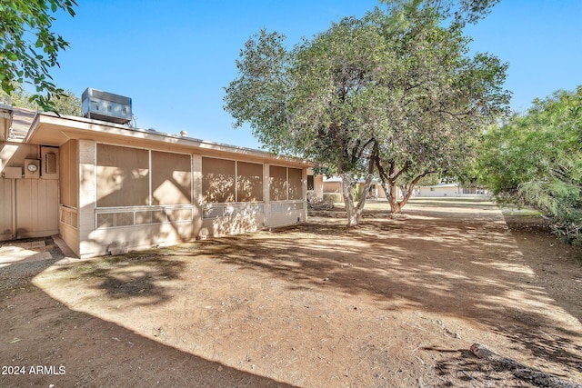 view of side of property with a sunroom and central air condition unit