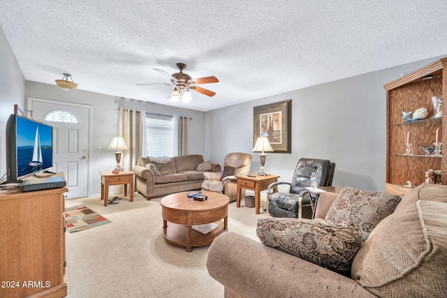 carpeted living room featuring ceiling fan and a textured ceiling