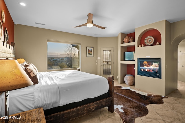 tiled bedroom featuring ceiling fan