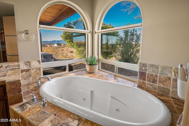 bathroom with tiled bath and wood ceiling