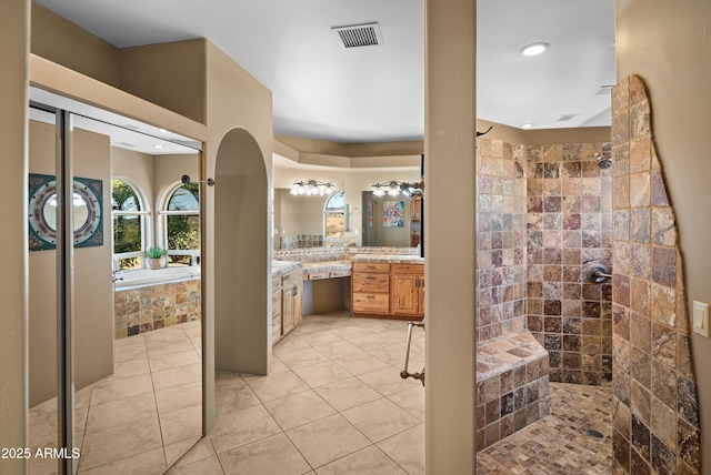 bathroom with vanity, tile patterned flooring, and plus walk in shower