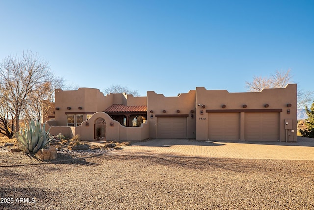 pueblo-style house featuring a garage