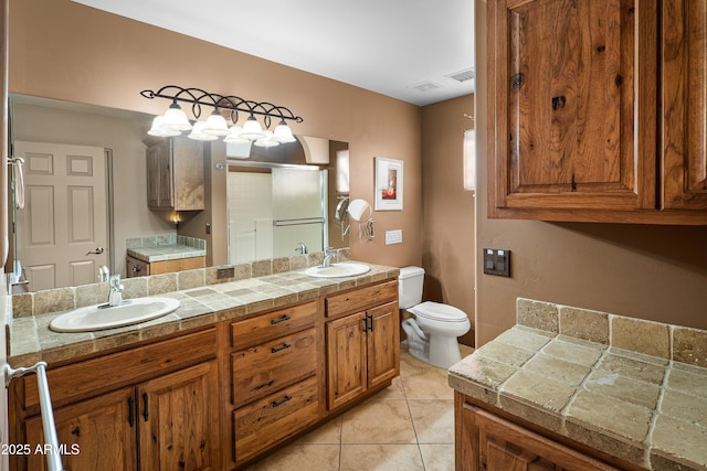 bathroom with toilet, tile patterned floors, an enclosed shower, and vanity