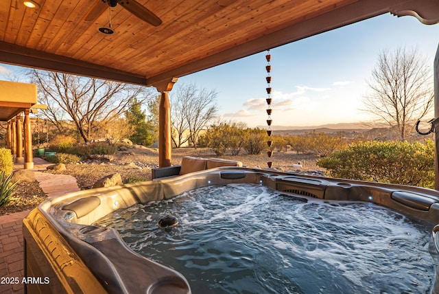 patio terrace at dusk featuring a hot tub