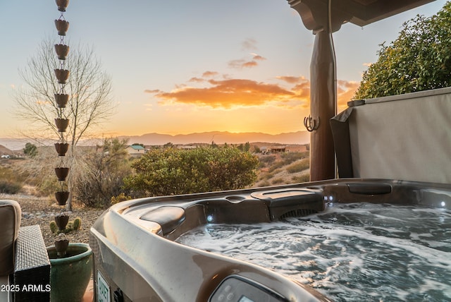 patio terrace at dusk with a mountain view and a hot tub