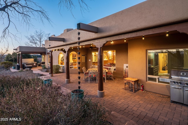 back house at dusk with a patio area