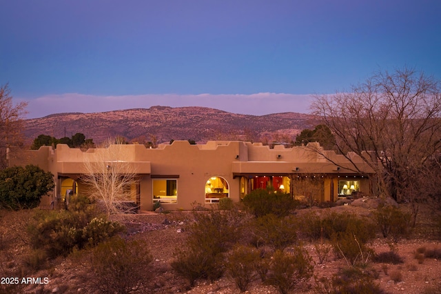 back house at dusk with a mountain view