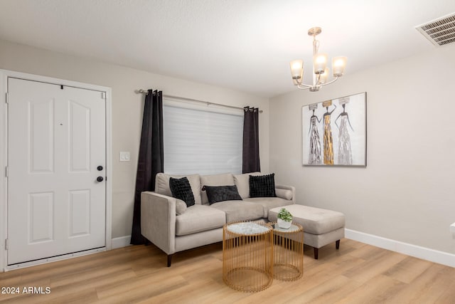 living room with an inviting chandelier and light hardwood / wood-style flooring