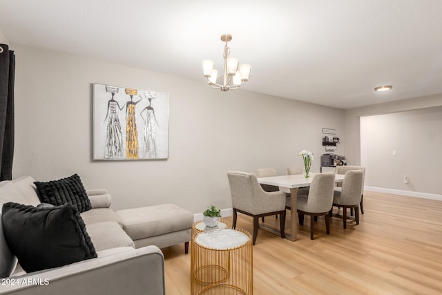 dining room with light hardwood / wood-style flooring and a notable chandelier