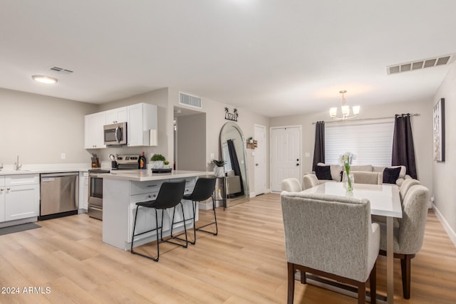 dining room featuring light hardwood / wood-style flooring, an inviting chandelier, and sink