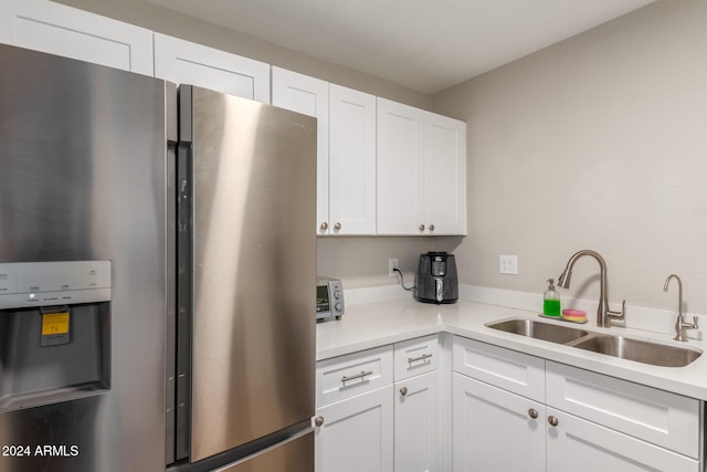 kitchen with white cabinets, stainless steel fridge with ice dispenser, and sink