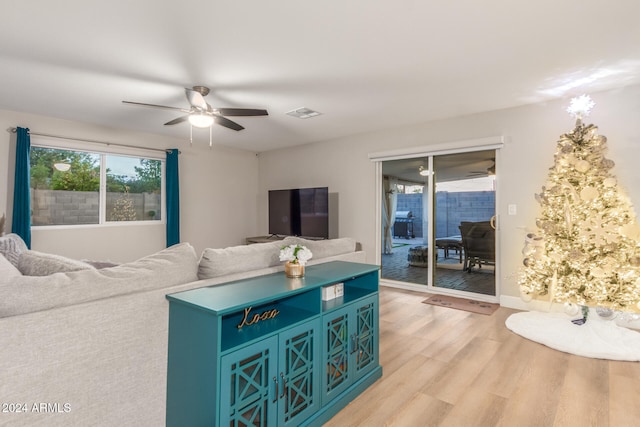 living room with light hardwood / wood-style flooring and ceiling fan