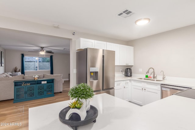 kitchen with white cabinetry, sink, light wood-type flooring, and appliances with stainless steel finishes