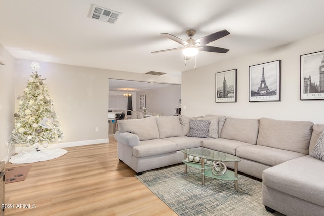 living room featuring hardwood / wood-style floors and ceiling fan with notable chandelier