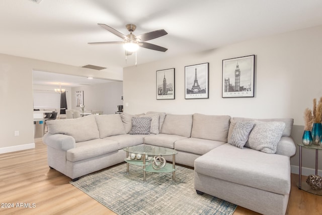 living room with hardwood / wood-style floors and ceiling fan with notable chandelier