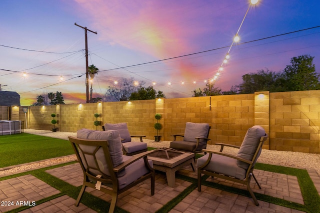 patio terrace at dusk with a yard and an outdoor fire pit