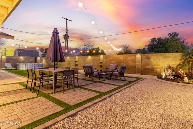 patio terrace at dusk featuring an outdoor living space