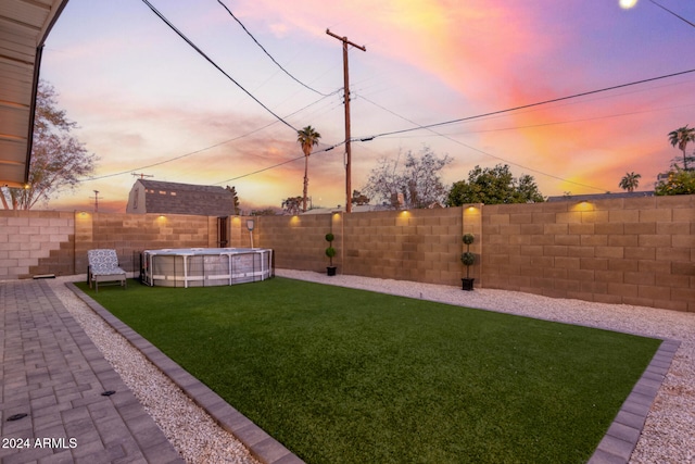 yard at dusk with a fenced in pool