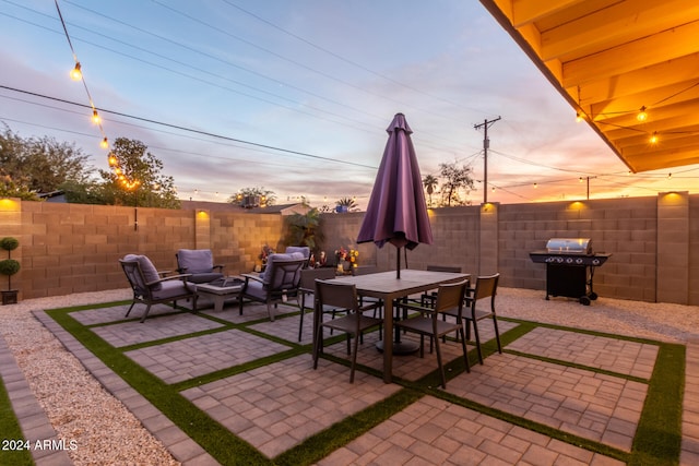 patio terrace at dusk featuring a grill and an outdoor hangout area