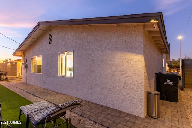 property exterior at dusk with a patio