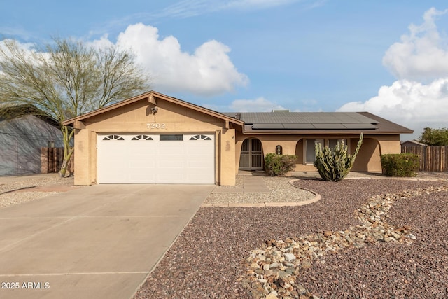 single story home featuring solar panels and a garage