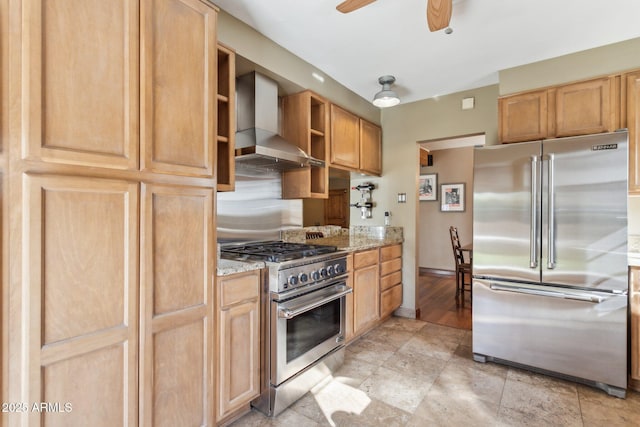 kitchen featuring a ceiling fan, wall chimney range hood, light stone countertops, open shelves, and high end appliances