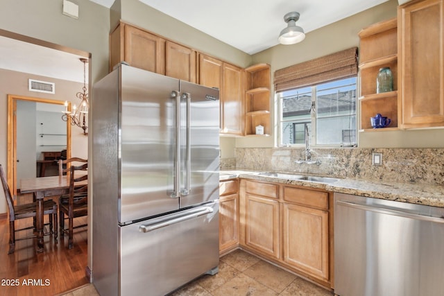 kitchen featuring open shelves, stainless steel appliances, visible vents, light brown cabinetry, and a sink