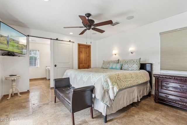 bedroom with a barn door, visible vents, ceiling fan, and baseboards